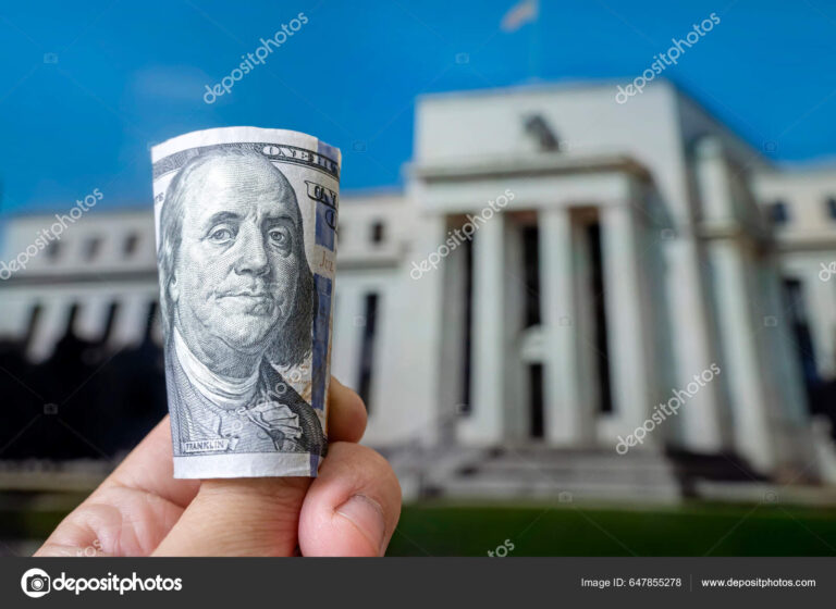 billetes de dolar y edificio de banco central