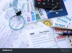 calculadora y billetes argentinos sobre mesa madera