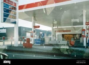 gasolinera con autos y precios visibles