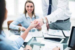 manos firmando contrato bancario juntos