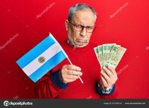 persona mayor feliz con billetes argentinos