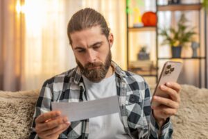 persona revisando factura telefonica en casa