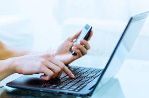 persona usando computadora y telefono movil