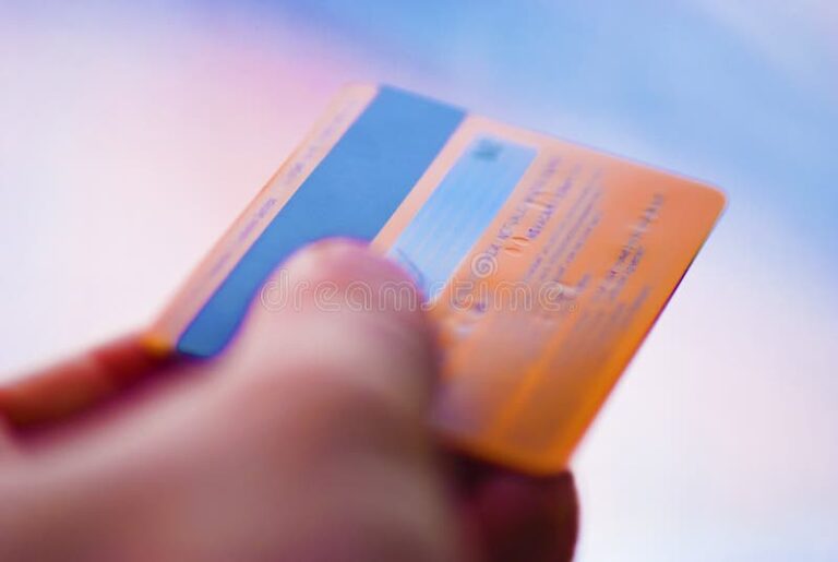 tarjeta de credito naranja brillante en mano